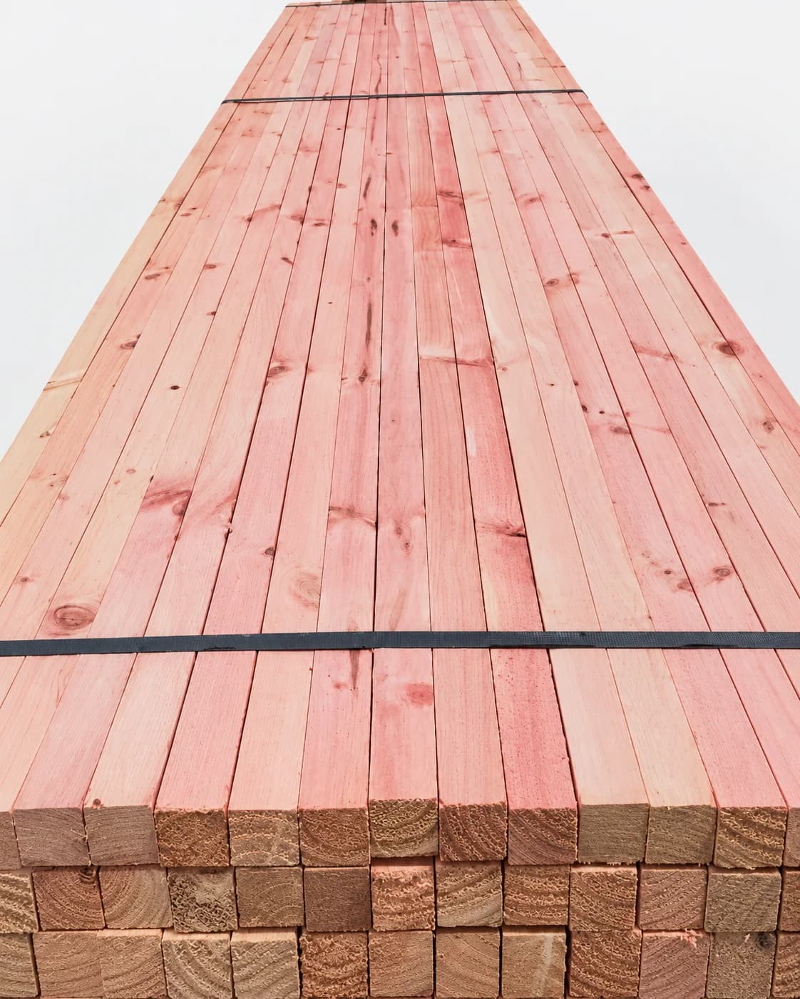 Pink treated Radiata Pine timber bundle for building applications.