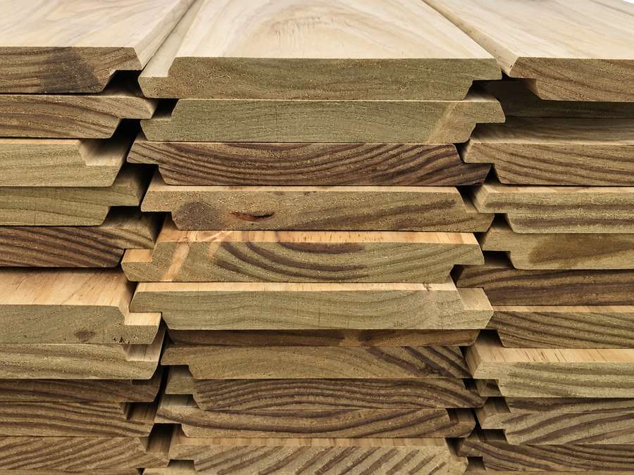 Stacked treated radiata pine cladding boards.